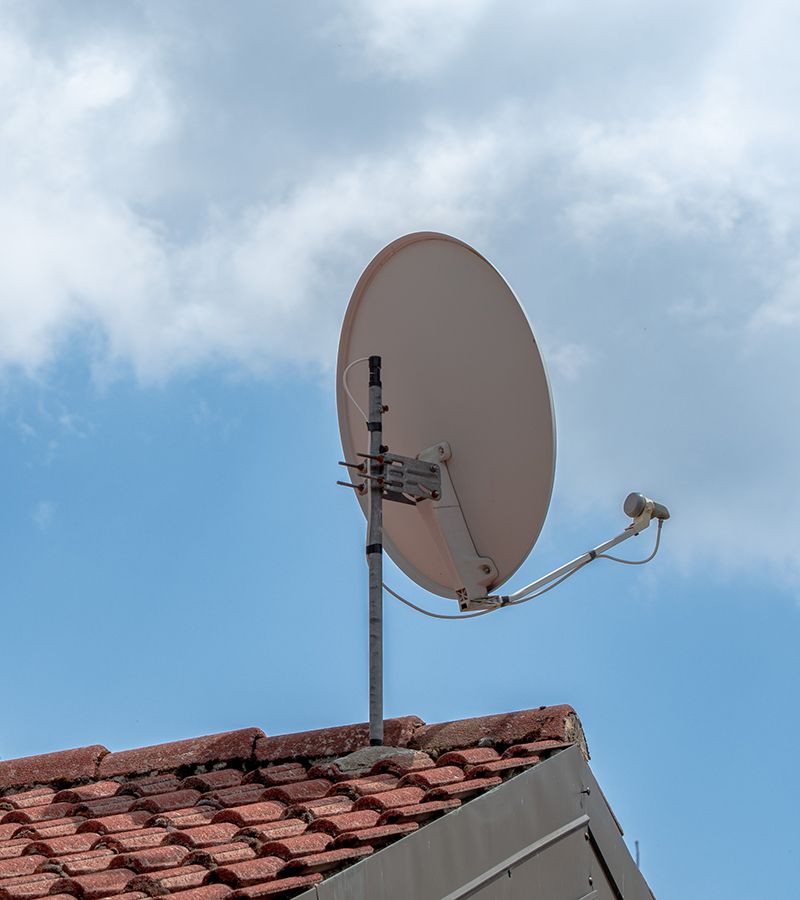 Antena parabólica encima de un tejado.